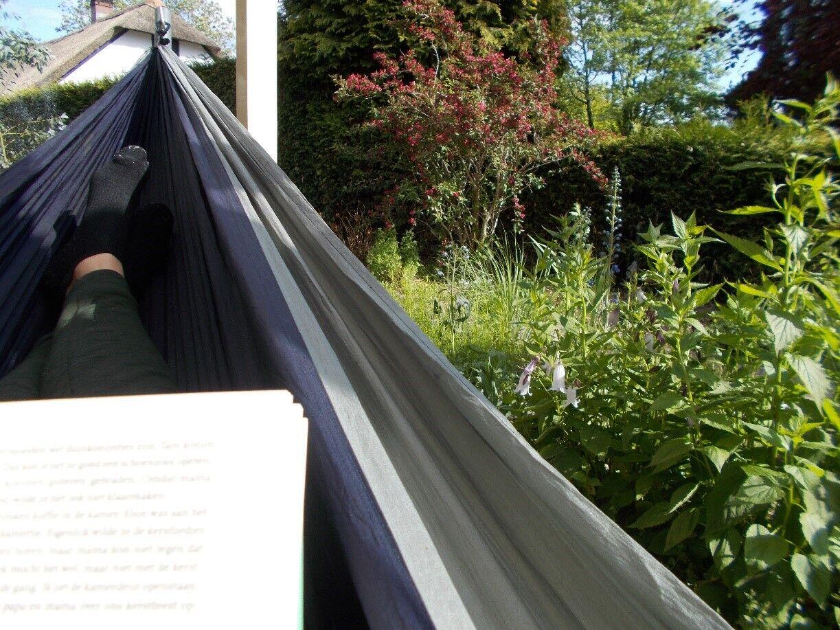 Lezen in de hangmat met uitzicht op mijn bloemrijke tuin